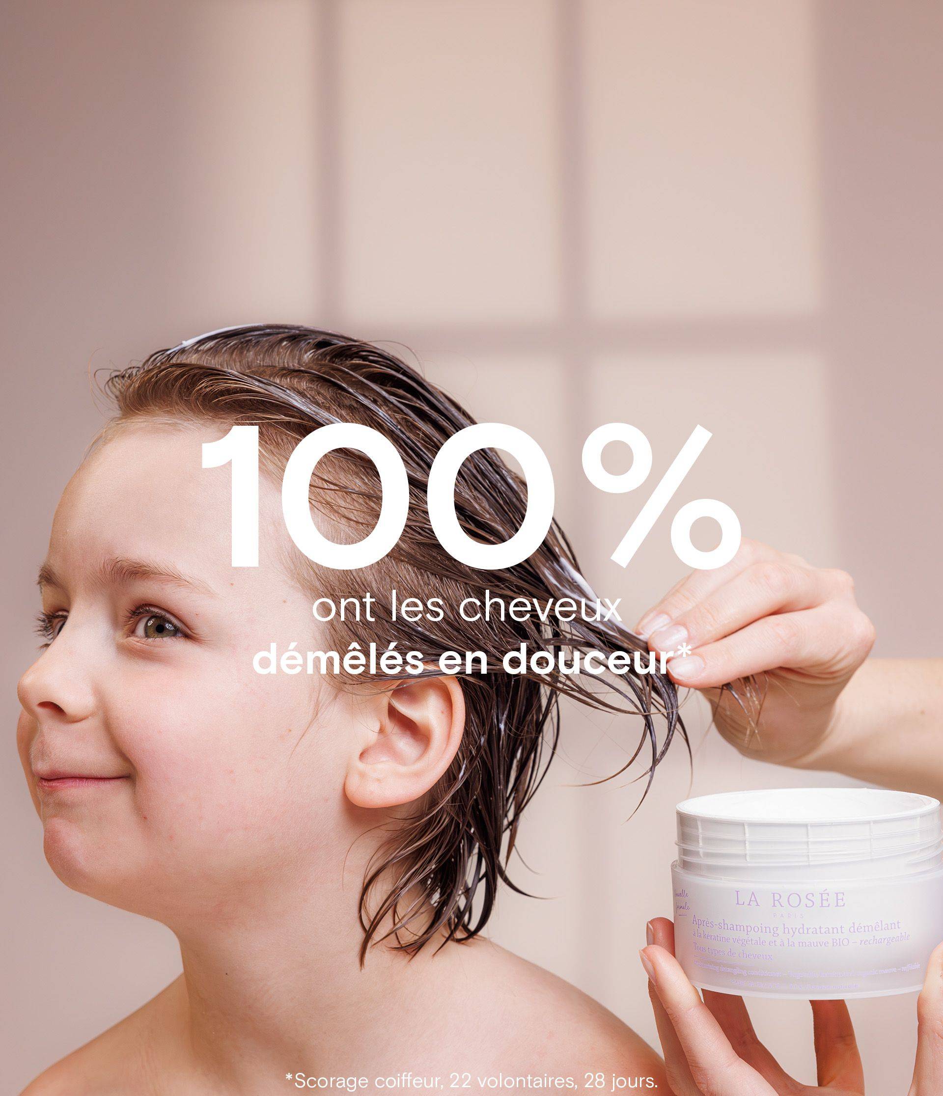 A child with wet hair is having conditioner applied to their hair. A hand holds a container labeled "La Rosée." Text overlay reads, "100% ont les cheveux démêlés en douceur."